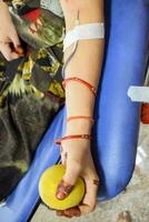 Blood donor at Blood donation camp held with a bouncy ball holding in hand at Balaji Temple, Vivek Vihar, Delhi, India, Image for World blood donor day on June 14 every year, Blood Donation Camp photo