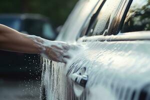 Lavado coche con jabón y agua. cerca arriba de hembra mano Lavado auto, manual coche lavar con blanco jabón, y espuma en el cuerpo. Lavado coche utilizando alto presión agua, ai generado foto