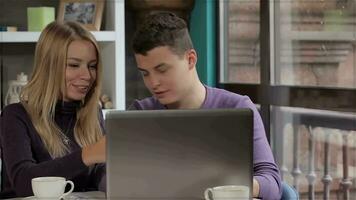 Couple looks at the laptop at the cafe video