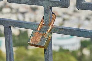 Padlocks symbolize unity and love forever. Locks hanging on fence ropes in the park. This tradition of locking locks comes from the belief that if a couple locks the keys together photo