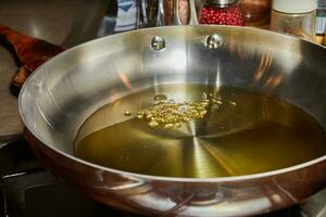 Olive oil in frying pan with chia grains photo