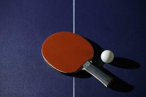 table tennis racket On the blue ping pong table photo