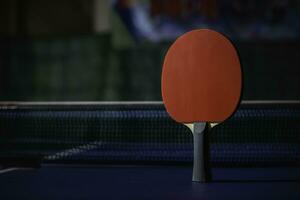 table tennis racket On the blue ping pong table photo