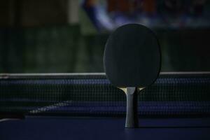 table tennis racket On the blue ping pong table photo