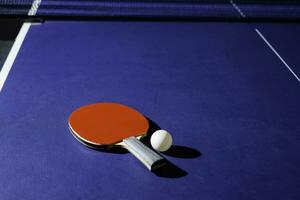 table tennis racket On the blue ping pong table photo