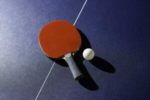 table tennis racket On the blue ping pong table photo