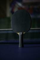 table tennis racket On the blue ping pong table photo