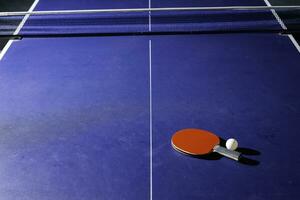 table tennis racket On the blue ping pong table photo