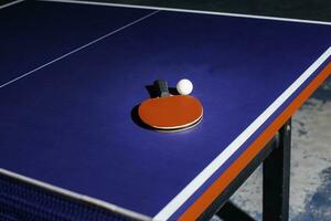 table tennis racket On the blue ping pong table photo