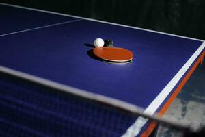 table tennis racket On the blue ping pong table photo