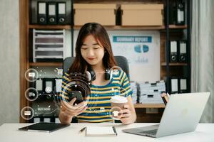 Woman using smart phone for mobile payments online shopping, omni channel, sitting on table, virtual icons graphics interface screen photo