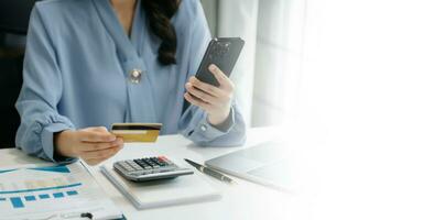 Woman using smart phone for mobile payments online shopping, omni channel, sitting on table, virtual icons graphics interface screen photo