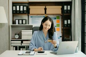 Woman using smart phone for mobile payments online shopping, omni channel, sitting on table, virtual icons graphics interface screen photo