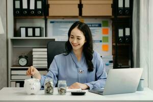 businesswoman holding coins putting in glass with using smartphone and calculator to calculate concept saving money for finance accounting photo