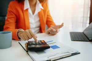 Hand business doing finances and calculate on desk about cost using on smartphone and tablet as concept photo