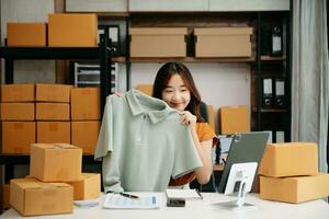 Asian lady blogger showing clothes in front of the camera to recording vlog video live photo