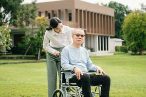 Happy adult granddaughter and senior grandfather having fun enjoying talk while relaxing sitting outdoor in park photo