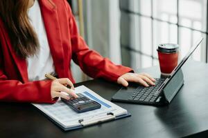 Hand business doing finances and calculate on desk about cost using on smartphone and tablet as concept photo