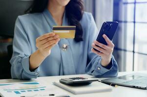 Woman using smart phone for mobile payments online shopping, omni channel, sitting on table, virtual icons graphics interface screen photo