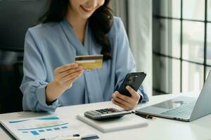 Woman using smart phone for mobile payments online shopping, omni channel, sitting on table, virtual icons graphics interface screen photo