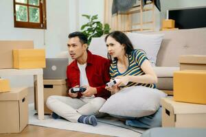 Asia young couple man and woman sit on couch use joystick controller play video game spend fun time together on sofa in living room. Asian married couple photo