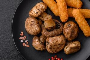 Delicious juicy whole champignons baked on the grill with salt and spices photo