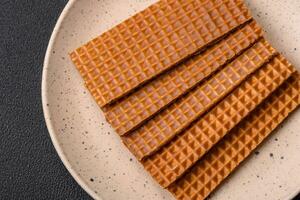 Delicious sweet crispy rectangular waffles on a ceramic plate photo