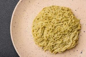 Capellini pasta o tallarines con pesto salsa, sal y especias foto