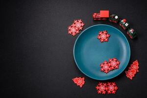 Ceramic round plate decorated with festive elements on the Christmas table photo