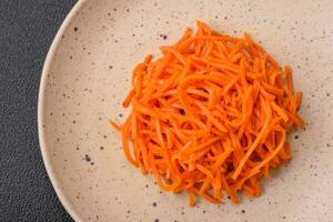 delicioso picante zanahorias rebanado y cocido en coreano estilo en un cerámico plato foto