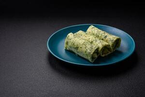 Delicious fresh pancakes with spinach, cream cheese, salmon, salt and spices photo