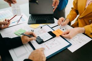 UX developer and ui designer brainstorming about mobile app interface wireframe design with customer breif and color code at modern office. photo