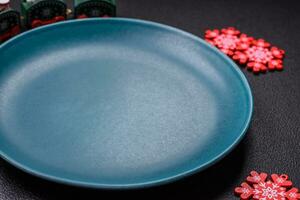 Ceramic round plate decorated with festive elements on the Christmas table photo