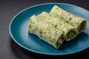 Delicious fresh pancakes with spinach, cream cheese, salmon, salt and spices photo