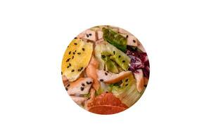 Delicious fresh juicy salad of sliced chicken, grapefruit, lettuce, sesame with olive oil photo