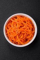 Delicious spicy carrots sliced and cooked in Korean style on a ceramic plate photo