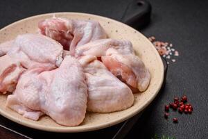 Fresh raw chicken wings with salt and spices prepared for baking photo