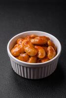 Delicious canned beans in a tomato in a round ceramic plate photo