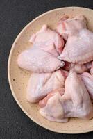 Fresh raw chicken wings with salt and spices prepared for baking photo