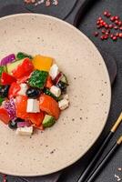 Delicious juicy Greek salad with feta cheese, olives, cucumber and tomatoes photo