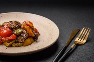 Warm salad with veal, tomatoes, peppers, zucchini, sesame, salt, spices and herbs photo