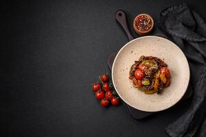 Warm salad with veal, tomatoes, peppers, zucchini, sesame, salt, spices and herbs photo