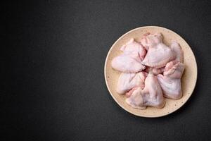 Fresh raw chicken wings with salt and spices prepared for baking photo