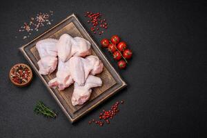 Fresh raw chicken wings with salt and spices prepared for baking photo