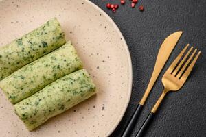 Delicious fresh pancakes with spinach, cream cheese, salmon, salt and spices photo