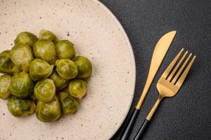 delicioso hervido Bruselas coles en un cerámico plato en un oscuro hormigón antecedentes foto