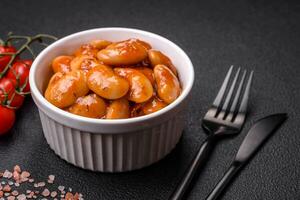 Delicious canned beans in a tomato in a round ceramic plate photo