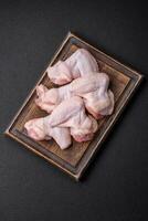 Fresh raw chicken wings with salt and spices prepared for baking photo