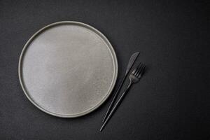 Empty round ceramic plate on a dark textured background photo