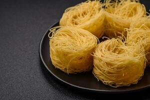 Raw capellini pasta or noodles with salt and spices photo